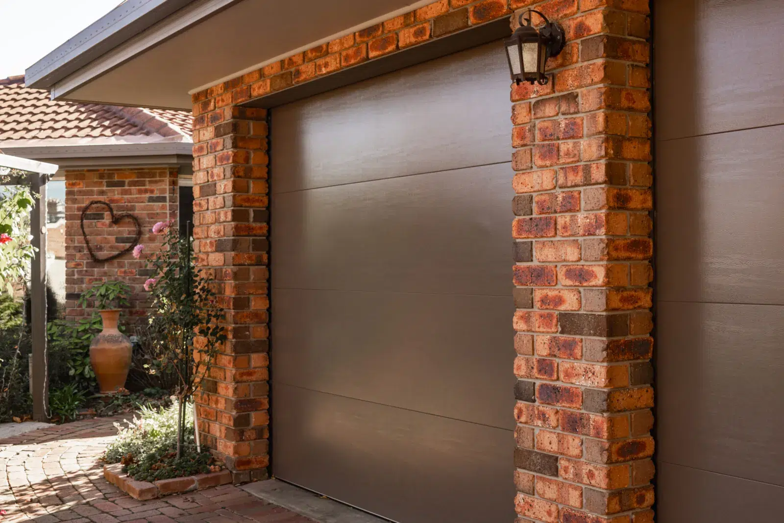 B&D Panelift sectional garage door in Jasper woodgrain set in a brick facade