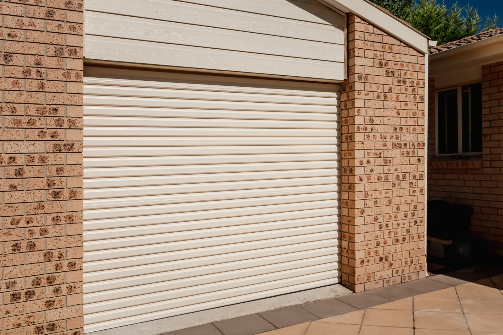 Classic Cream B&D Roll-A-Door roller garage door on a brick home