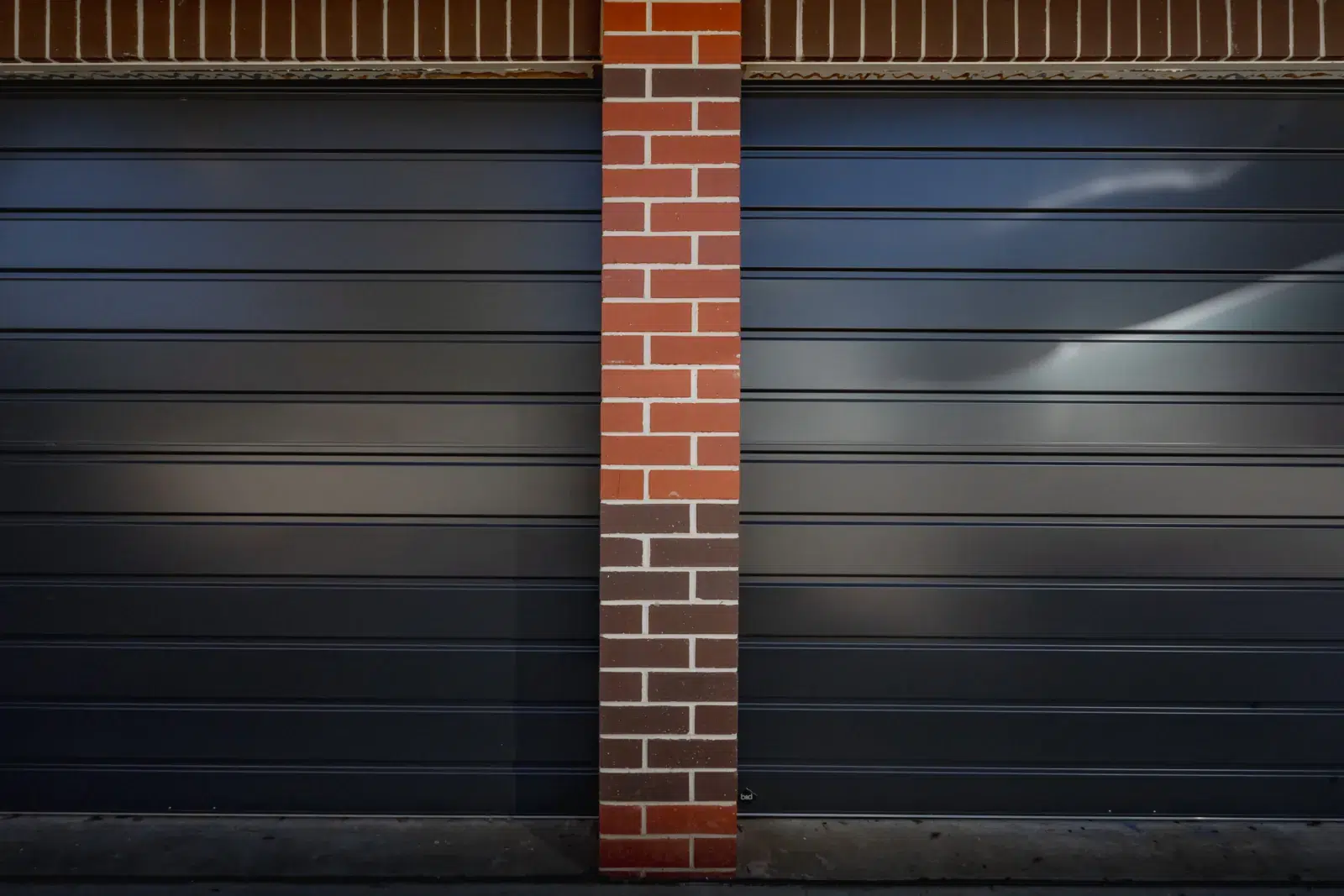 Two Roll-A-Door Neo roller doors in Monument separated by a brick pier